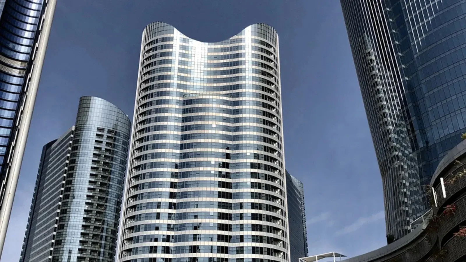 Main entrance exterior at Omega Tower Al Reem Island Abu Dhabi with an arrival drive and clear commercial building signage