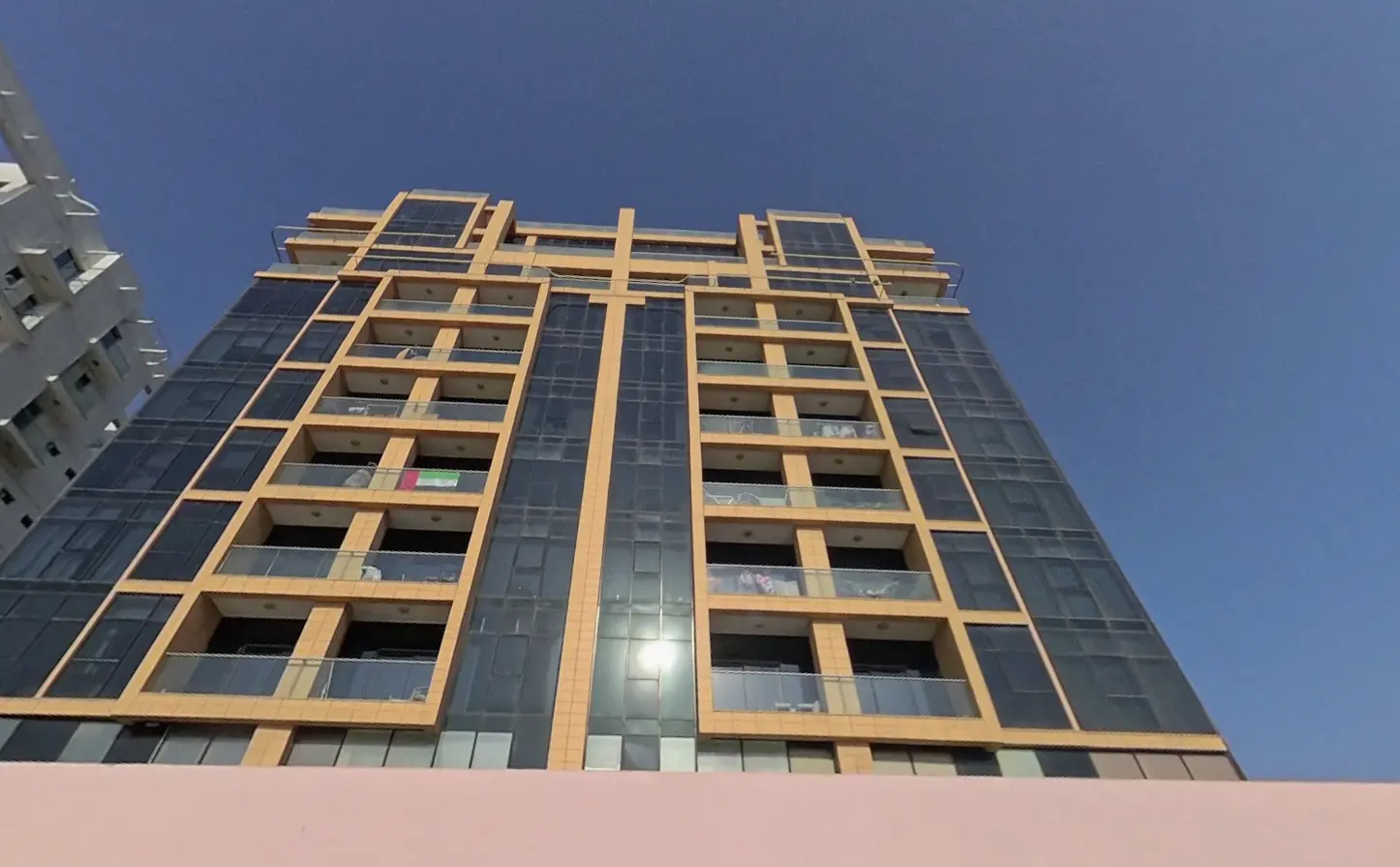 Exterior night view of illuminated luxury balconies at Al Qurm View residential tower in Shams Abu Dhabi UAE