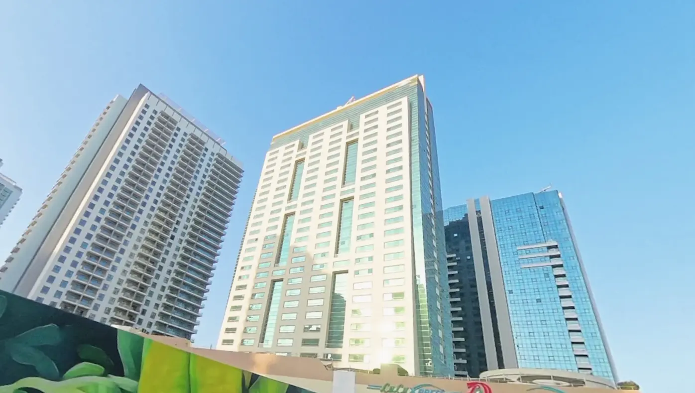 Panoramic city skyline and coastal views from private glass balcony at Burj Al Shams Abu Dhabi property