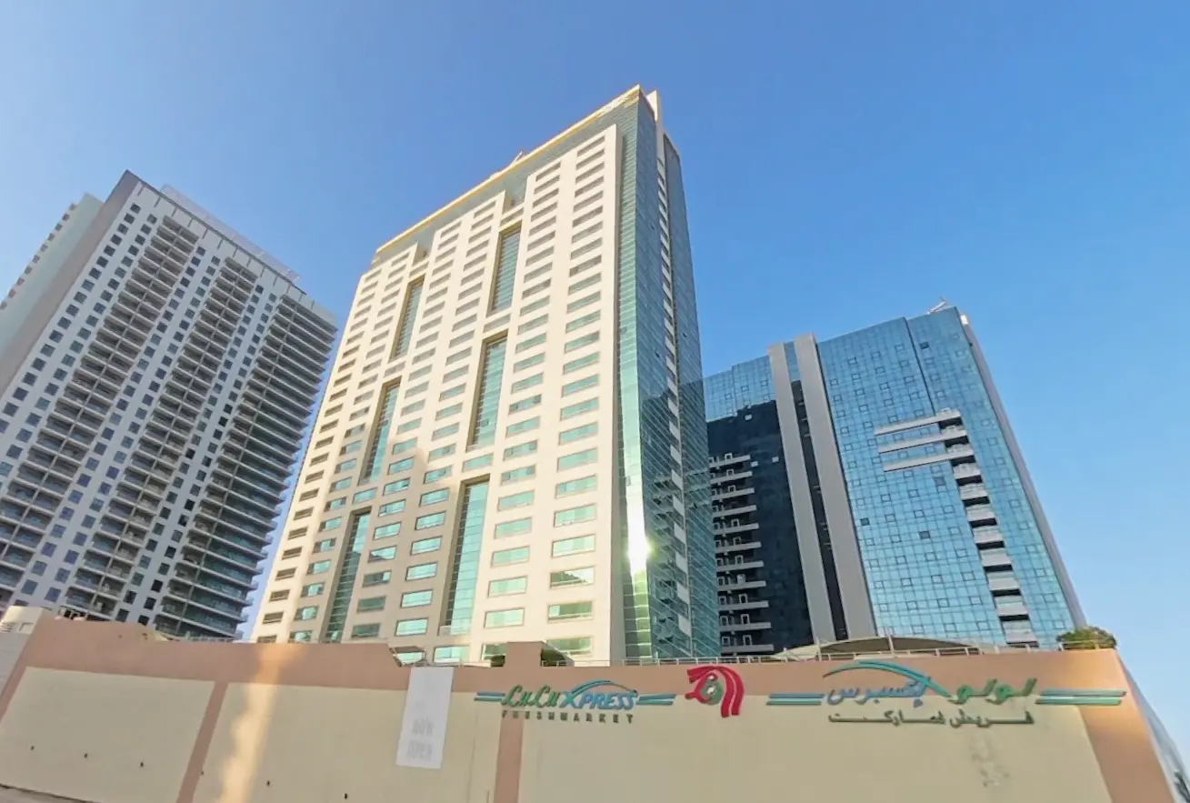 Outdoor swimming pool deck and sun loungers at Burj Al Shams residential tower in Shams Abu Dhabi