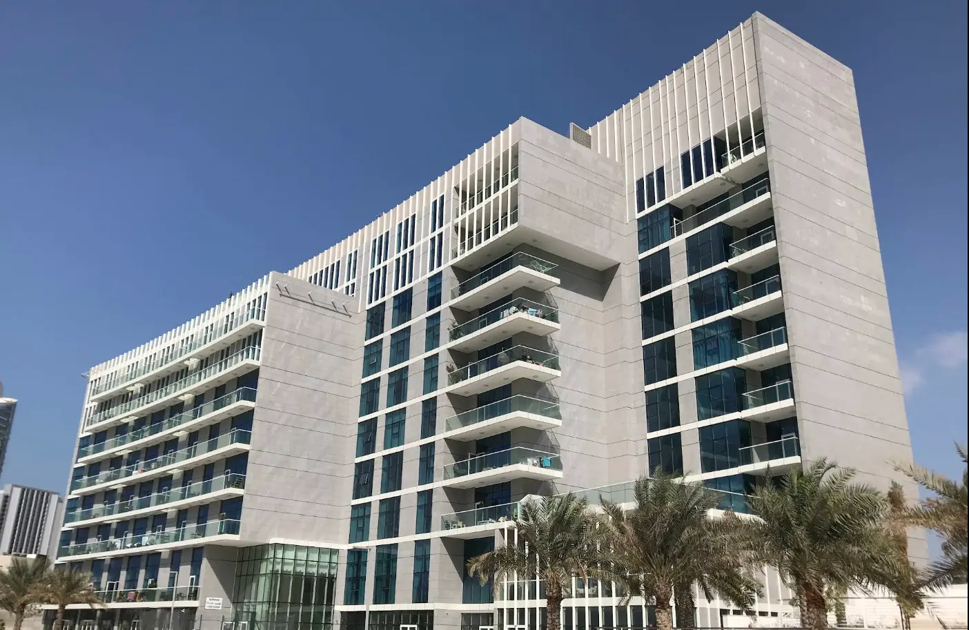 Illuminated evening exterior view highlighting the boutique architecture of By The Sea Tower in Shams Abu Dhabi.
