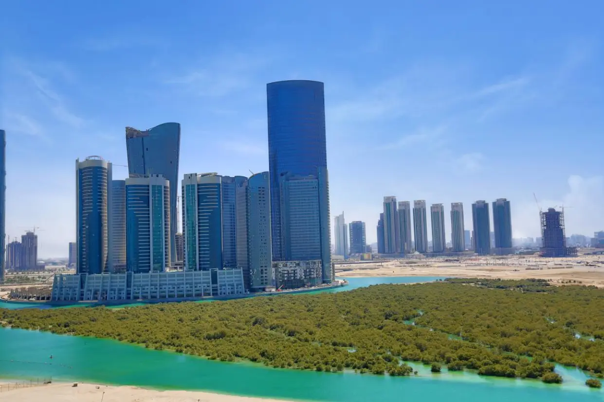 Contemporary Abu Dhabi cityscape at Marina Spirit City of Lights showing high-rise towers beside turquoise waters and green mangroves.