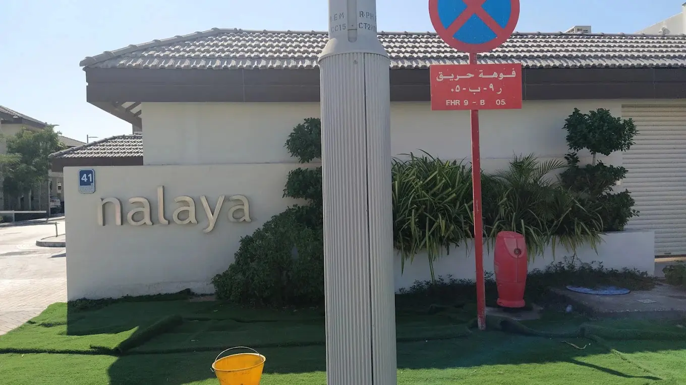 Outdoor swimming pool deck and sun lounge facility anchored next to the clubhouse at Nalaya Najmat Al Reem