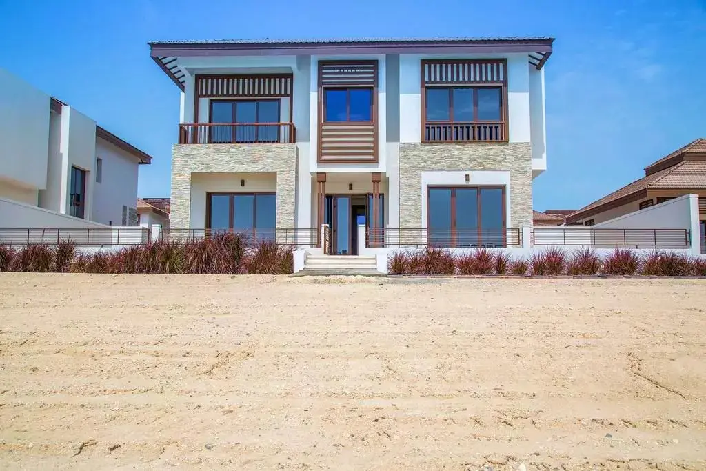 Coastal villa elevation displaying upper viewing balconies facing the Arabian Gulf at Nalaya Najmat Abu Dhabi
