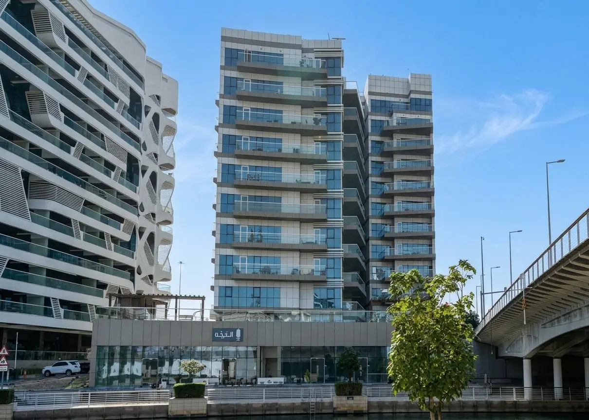 Shared outdoor swimming pool deck and lounge cabanas located within Al Amirah Building complex