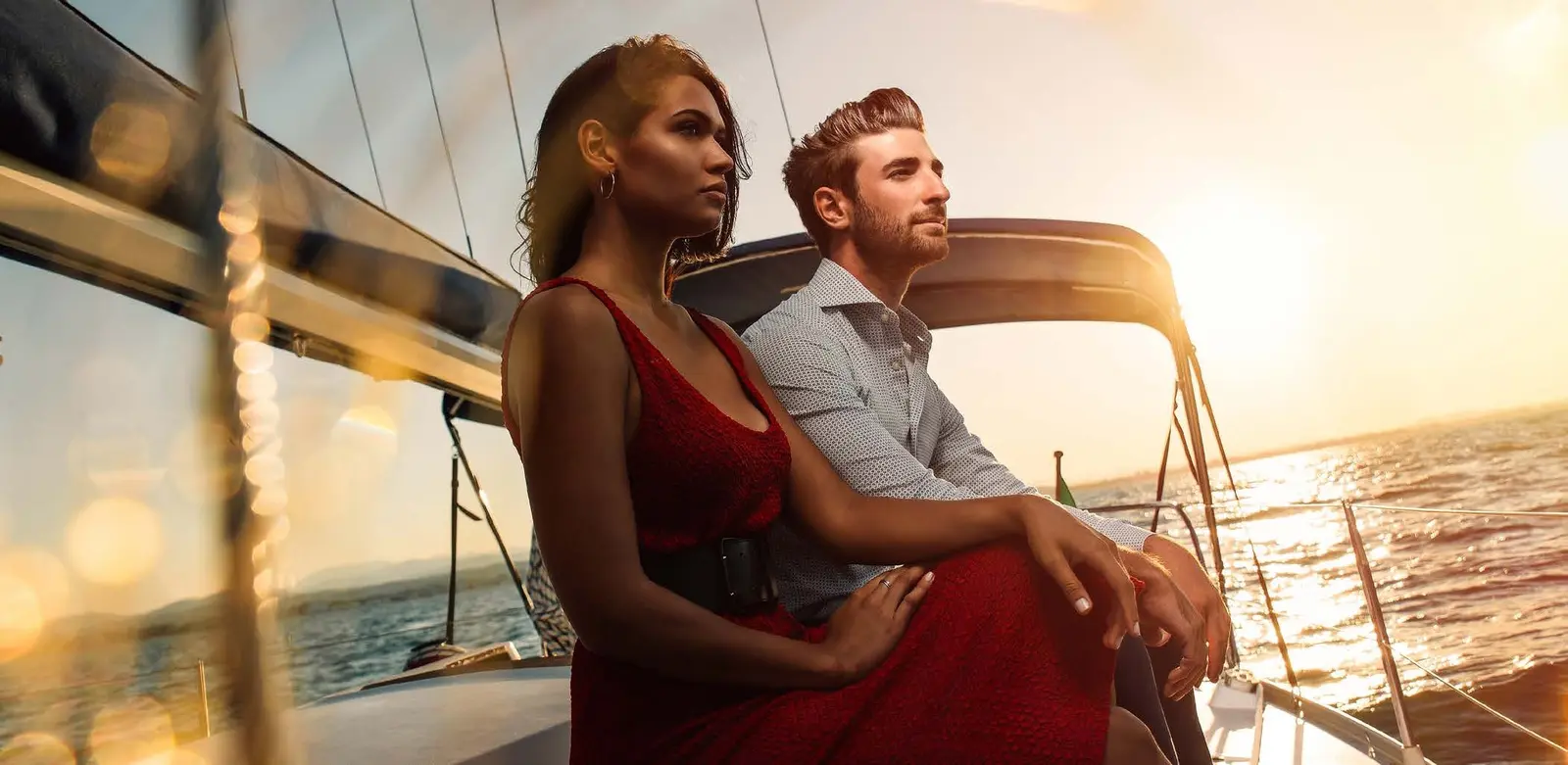 Yachtside Marina Residences at Sobha Siniya Island couple enjoying sunset cruise on luxury private yacht deck