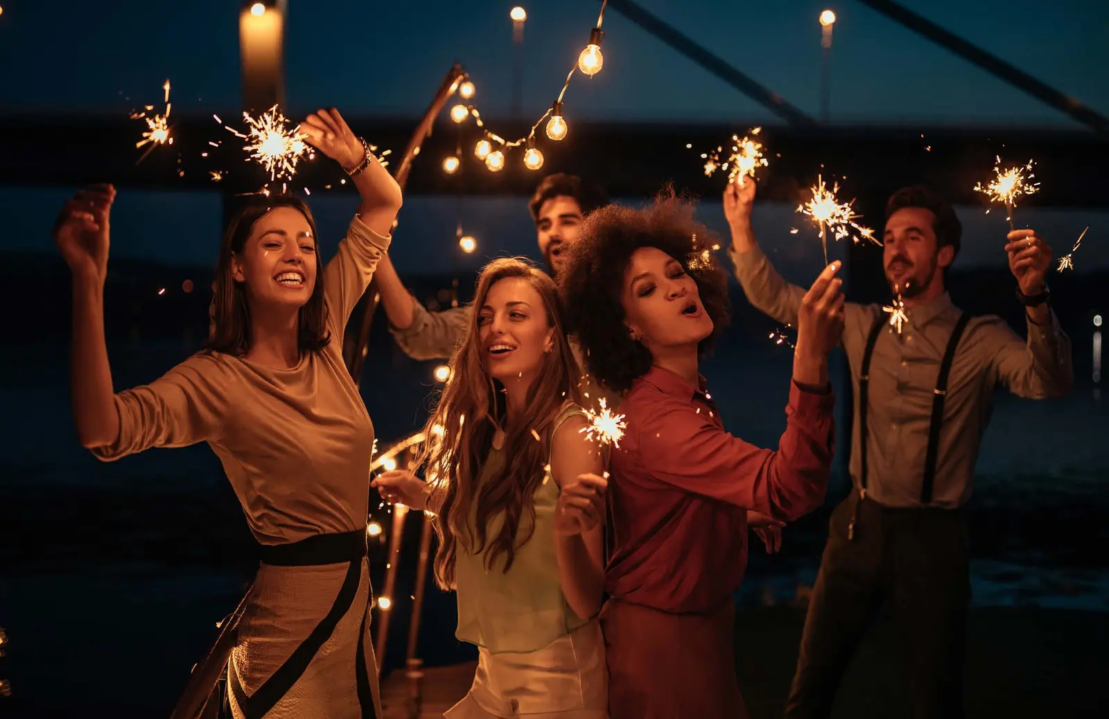 Yachtside Marina Residences at Sobha Siniya Island friends celebrating vibrant waterfront evening nightlife with sparklers outdoors