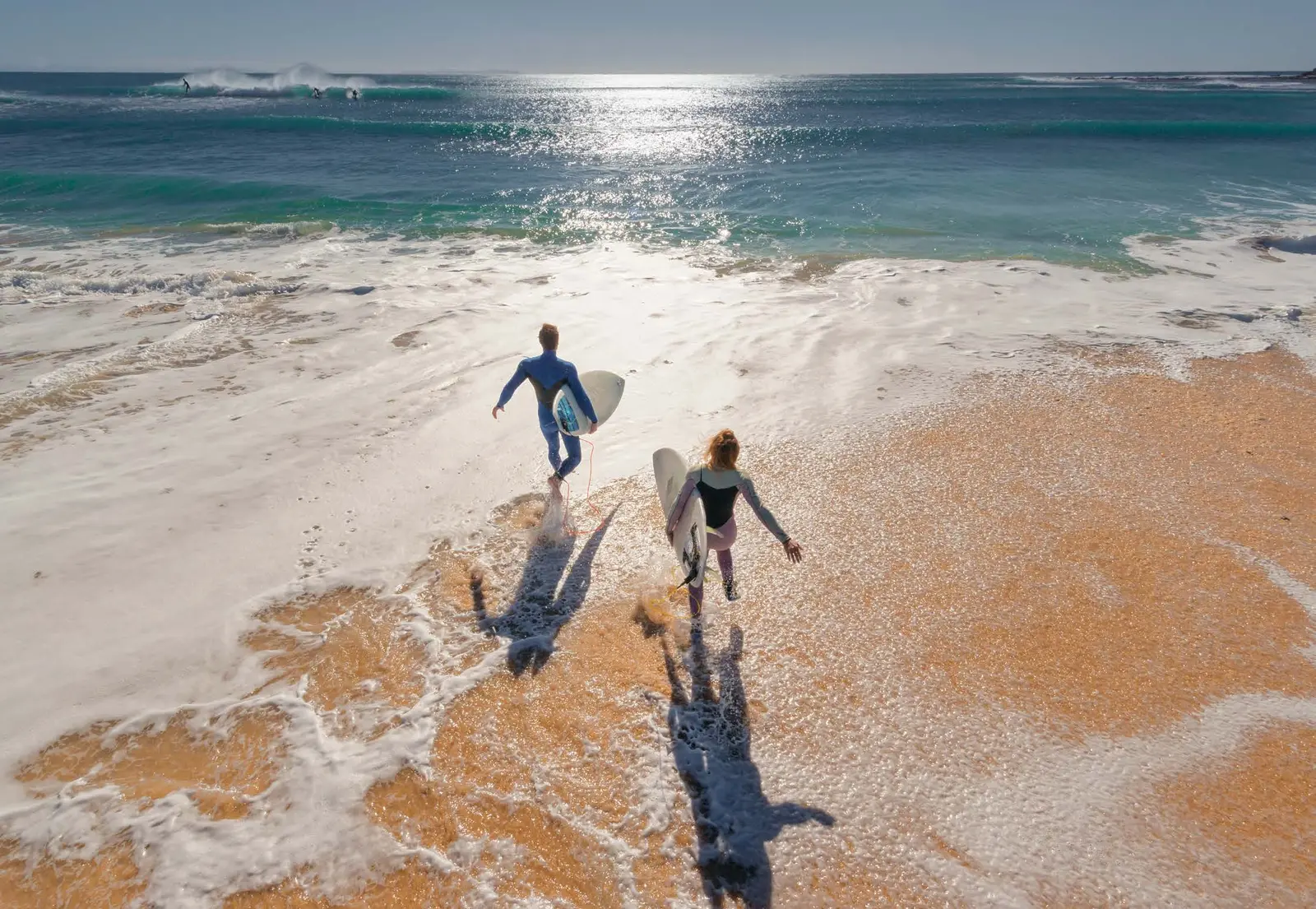 Yachtside Marina Residences at Sobha Siniya Island Umm Al Quwain residents enjoying pristine white sandy beach surfing