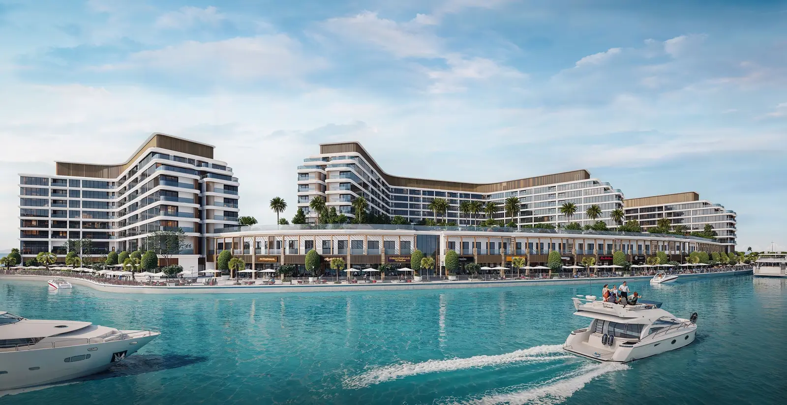 Mid rise residential towers and waterfront promenade with cruising yachts at Bayfront Marina Residences Sobha Siniya Island.