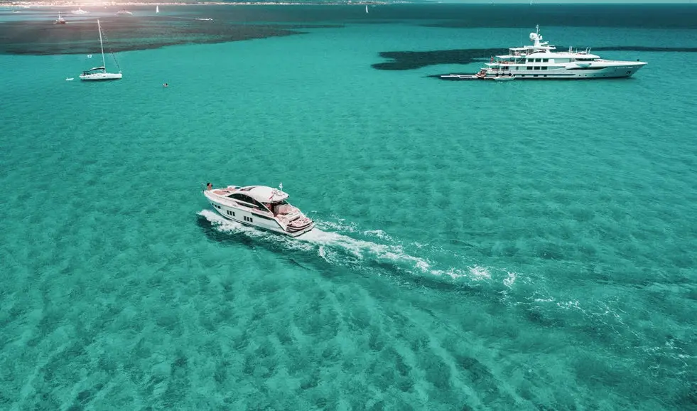 Aerial view of luxury motorboats cruising on crystal clear turquoise waters at Bayside Marina Residences on Sobha Siniya Island