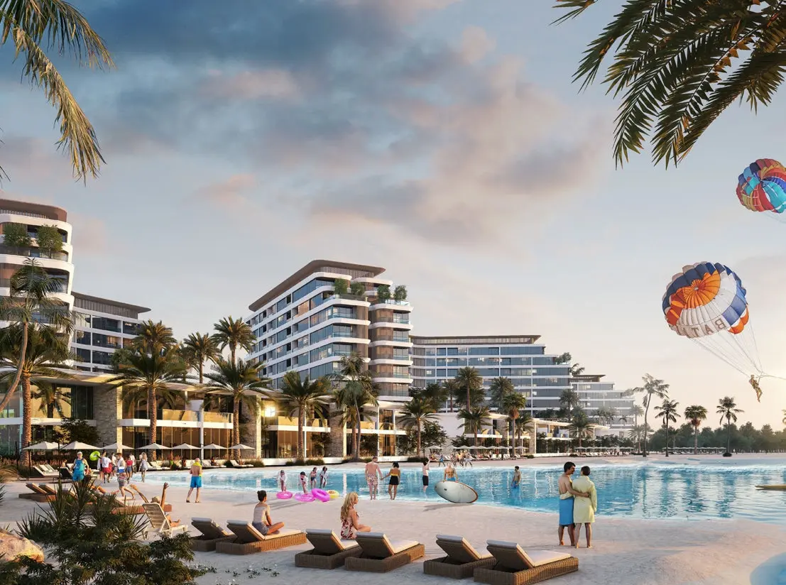 People relaxing by the outdoor swimming pool with luxury resort buildings at Bayside Marina Residences on Sobha Siniya Island