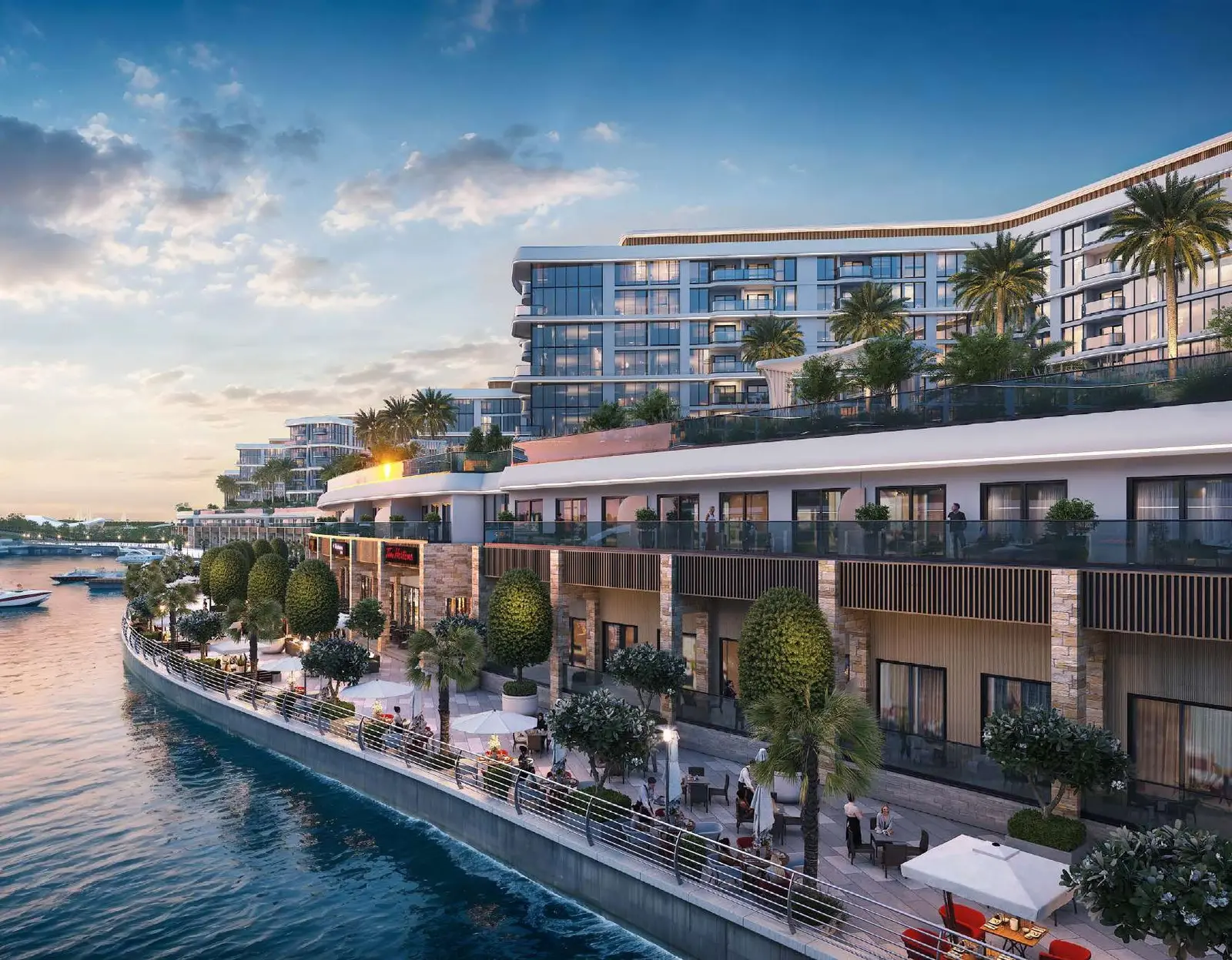 Evening illuminated waterfront promenade with dining setups at Pierside Marina Residences Sobha Siniya Island UAQ