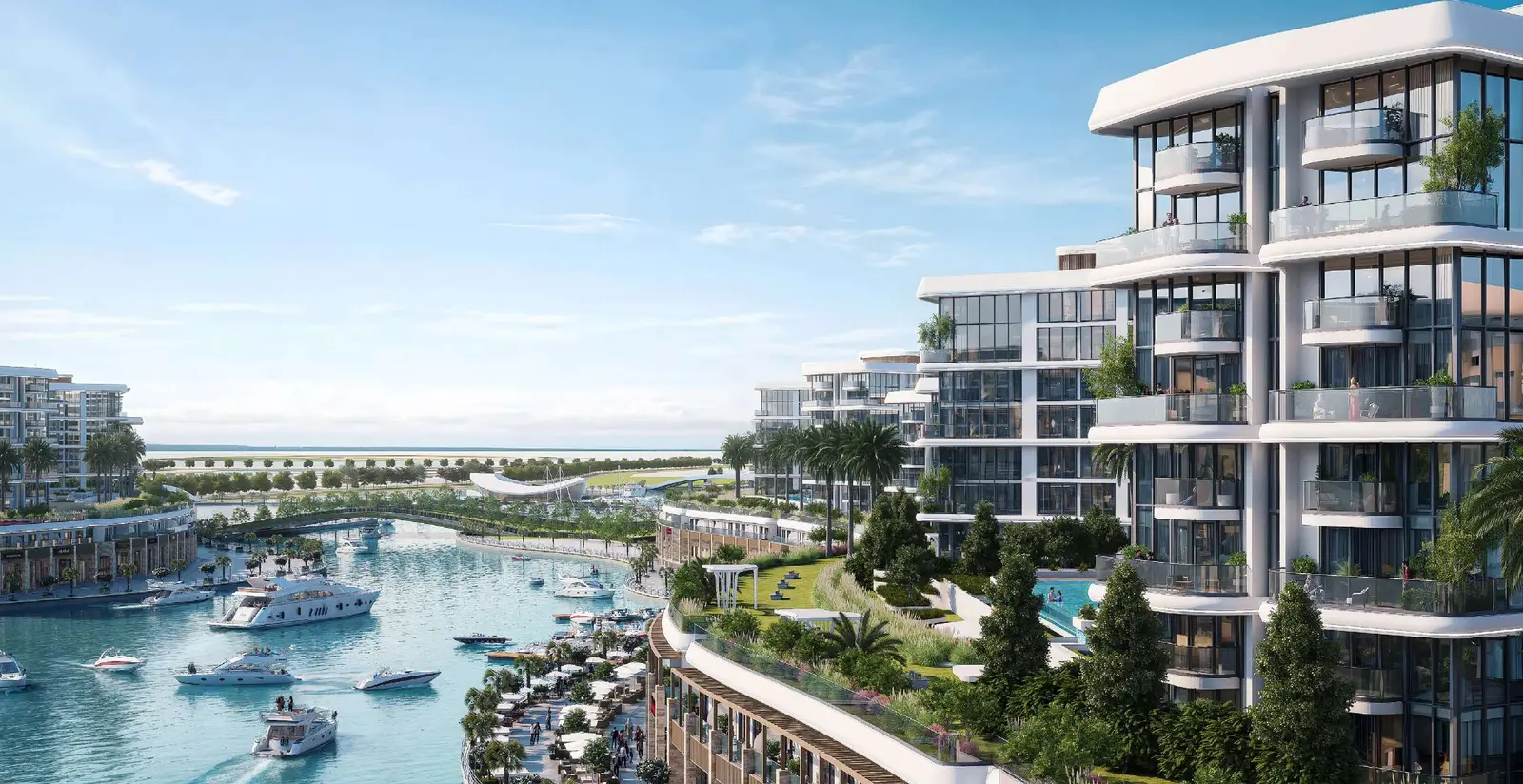 Waterfront residential blocks with landscaped greenery and canal bridge at Pierside Marina Residences Sobha Siniya Island UAQ