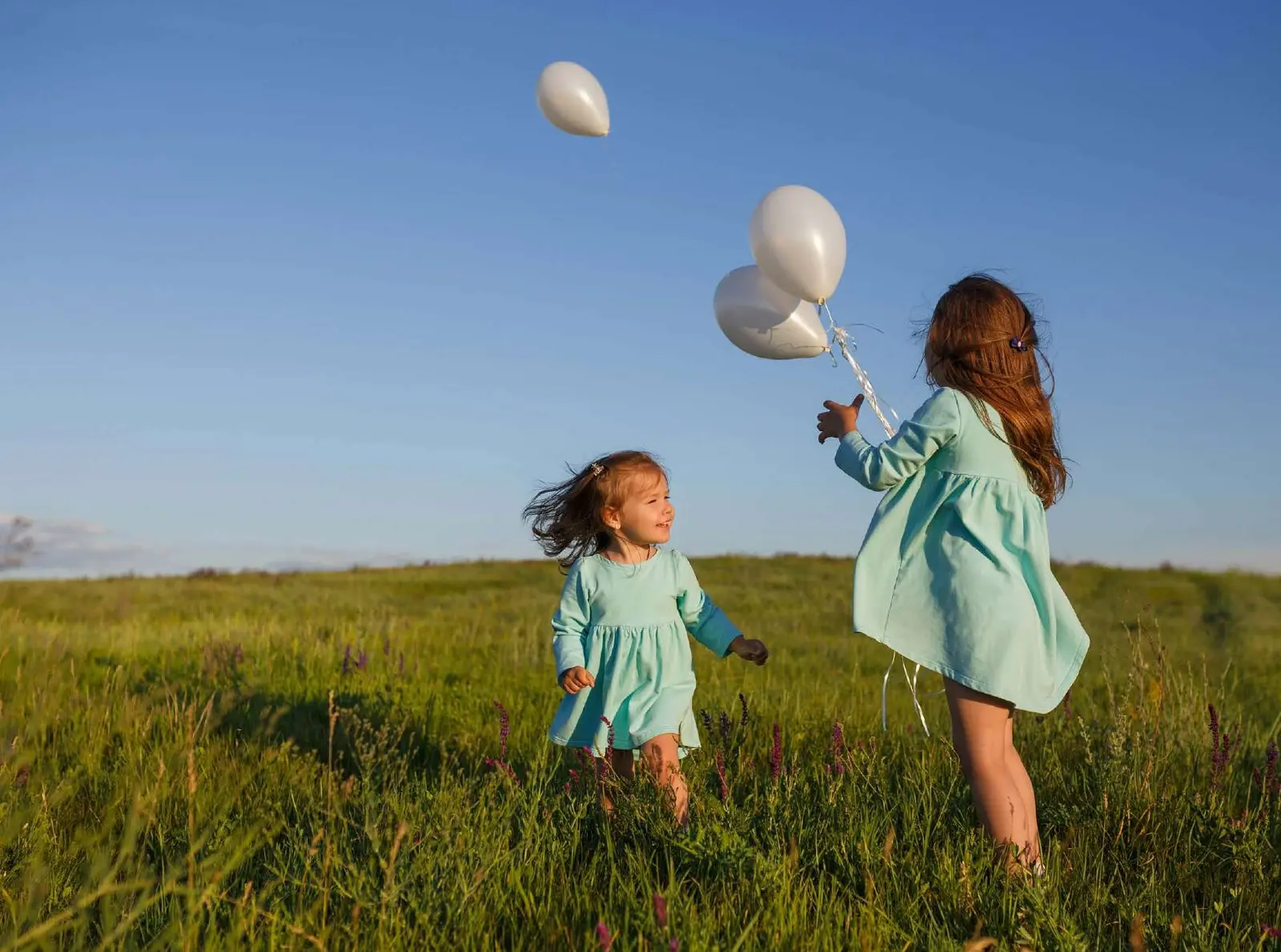 Children playing in lush green park areas within Sobha Siniya Island community near Pierside Marina Residences UAQ