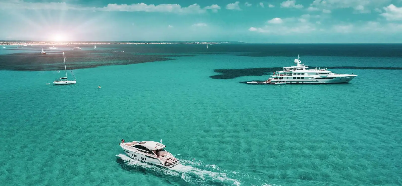 Luxury yachts navigating open sea waters around Sobha Siniya Island community near Pierside Marina Residences UAQ