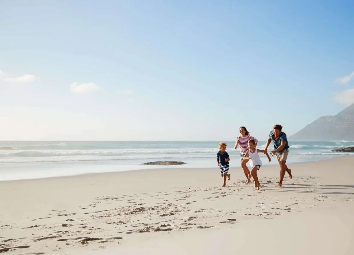 Wide beach view of family enjoying coastal lifestyle near Pierside Marina Residences Sobha Siniya Island UAQ