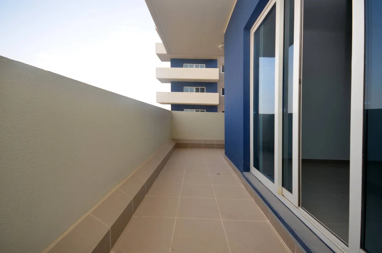 Spacious one-bedroom apartment living area at Al Reef Downtown Abu Dhabi showcasing contemporary interior design and comfort for modern residents