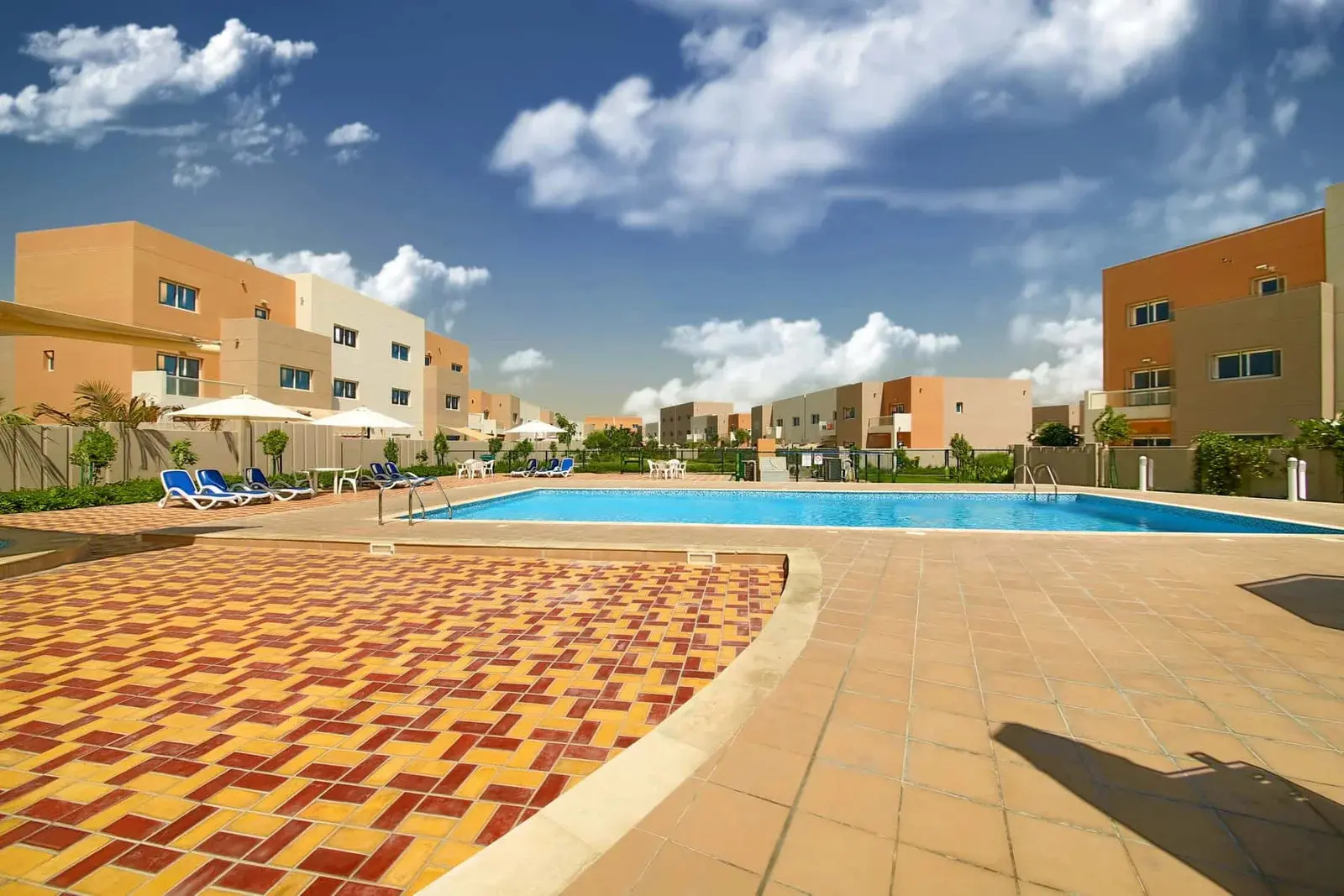Clubhouse exterior at Al Reef Villas featuring modern design and pool area