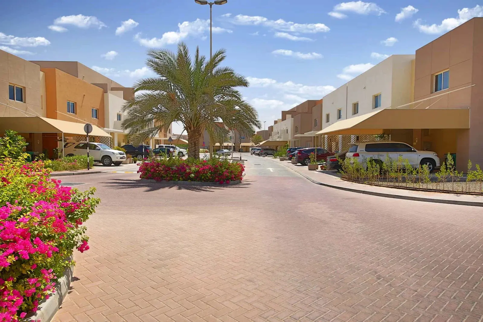 Streetscape view inside Al Reef Villas showing villa rows and landscaped roads