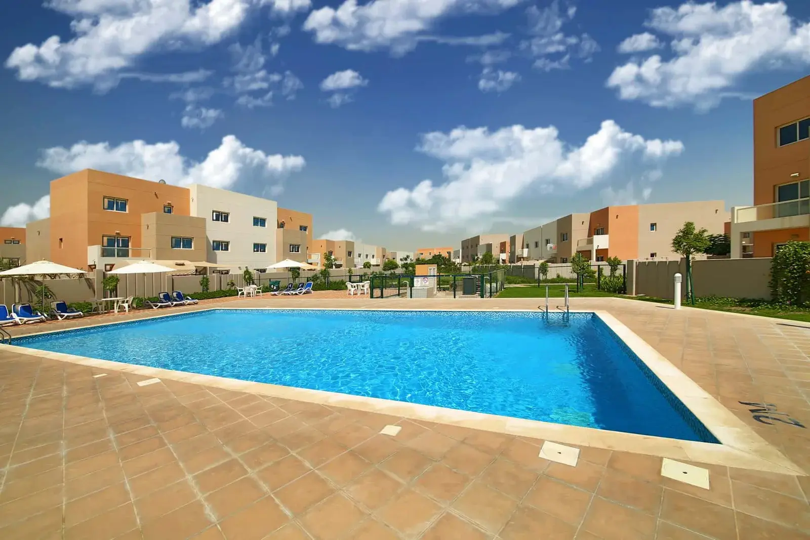 Private garden at Al Reef Villas with outdoor seating, greenery, and stone pathways
